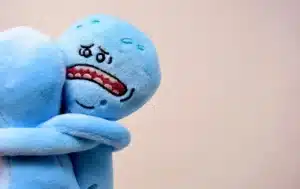 Foto di due pupazzi di peluche azzurri raffigurati mentre si abbracciano, con quello visibile in volto che mostra un'espressione trista e disperata, usato per riferirsi al dolore che vive nel lasciarsi chi soffre di dipendenza affettiva, tema di cui si occupa lo psicologo Alessio Congiu